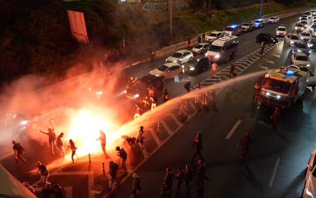 Des manifestants anti-gouvernement bloqueant l'autoroute Ayalon à Tel Aviv alors que la police utilise des canons à eau contre eux le 6 juillet 2024. (Crédit : Lior Segev/Mouvement de protestation pour la démocratie en Israël) Des manifestants anti-gouvernement bloqueant l'autoroute Ayalon à Tel Aviv alors que la police utilise des canons à eau contre eux le 6 juillet 2024. (Crédit : Lior Segev/Mouvement de protestation pour la démocratie en Israël)