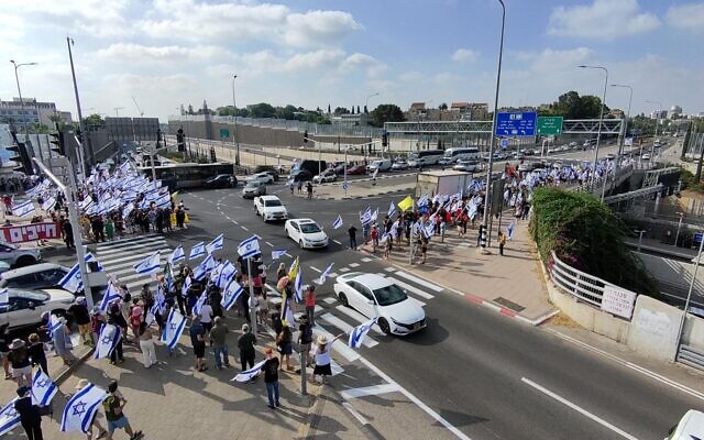 Des manifestants anti-gouvernement à la jonction entre Herzliya et Ra'anana lors d'une "journée de perturbation" appelant à des élections et à un accord pour les otages, le 7 juillet 2024. (Crédit : Raya Barkan/Groupes de protestation pour la démocratie)