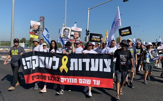 Des proches d'otages entame le deuxième jour d'une marche de quatre jours de Tel-Aviv à Jérusalem pour réclamer un accord sur les otages et la fin de la guerre, le 11 juillet 2024. (Crédit : Charlie Summers/Times of Israel) Des proches d'otages entame le deuxième jour d'une marche de quatre jours de Tel-Aviv à Jérusalem pour réclamer un accord sur les otages et la fin de la guerre, le 11 juillet 2024. (Crédit : Charlie Summers/Times of Israel)