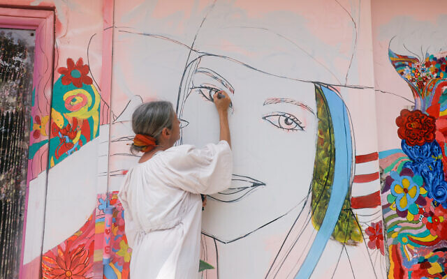 Une artiste peint une fresque à Tel Aviv, en hommage à Tamar Goldenberg, tuée par le Hamas au festival Supernova. (Crédit : Limor Ben Romano)