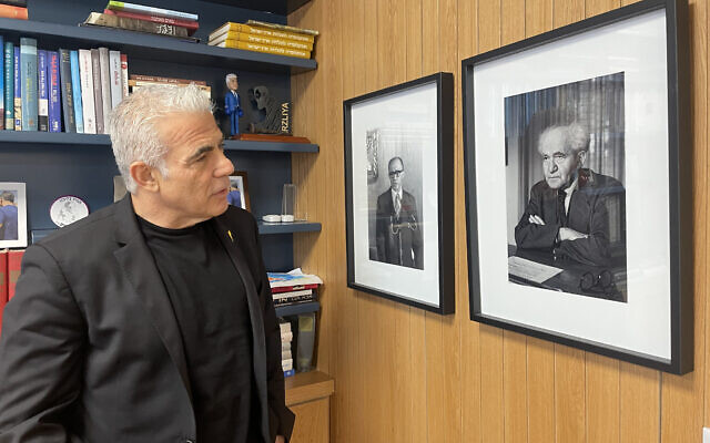 Image principale : Le chef de l'opposition Yair Lapid regarde les portraits des anciens Premiers ministres Menachem Begin et David Ben Gurion lors d'un interivew dans son bureau de Tel Aviv, le 22 août 2024. (Crédit : Sam Sokol/The Times of Israel)