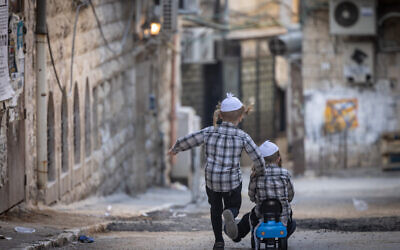 Des enfants ultra-orthodoxes jouant dans le quartier haredi de Mea Shearim, à Jérusalem, le 26 juin 2024. (Crédit : Chaïm Goldberg/Flash90)