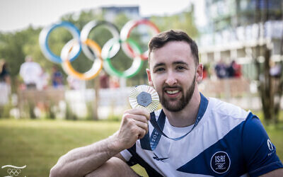 Le gymnaste olympique Artem Dolgopyat pose pour une photo avec sa médaille d'argent à Paris avant son retour en Israël, le 4 août 2024. (Crédit : Comité olympique d'Israël)
