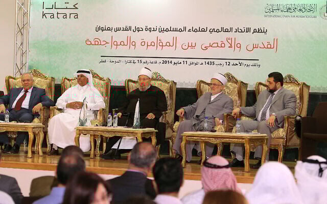 Le clerc égyptien et président de l'Union internationale des savants musulmans Cheikh Yusuf al-Qaradawi (au centre) et l'ancien chef du Hamas palestinien au Liban, Osama Hamdan (à droite), assistent à un séminaire intitulé « Jérusalem et Al-Aqsa entre conspiration et confrontation » dans la capitale qatarie Doha, le 11 mai 2014. (Crédit : KARIM JAAFAR / AL-WATAN DOHA / AFP)