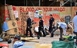 Illustration : La police patrouille alors que des ouvriers nettoient des graffitis anti-israéliens sur le campus de l'Université de Californie à Los Angeles (UCLA) après que la police a expulsé des manifestants pro-palestiniens, le 2 mai 2024. (Crédit : Frederic J. Brown/AFP)
