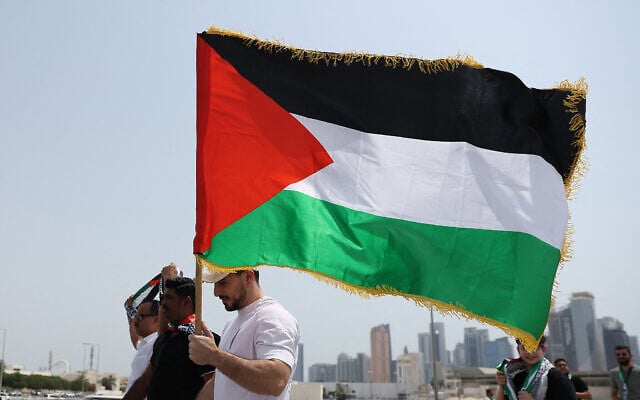 Des personnes brandissant des drapeaux palestiniens se dirigeant vers la mosquée Imam Mohammed ben Abdul Wahhab à Doha pour rendre hommage au chef du Hamas Ismaïl Haniyeh après son assassinat à Téhéran en début de semaine, le 2 août 2024. (Crédit : Karim Jaafar/AFP)