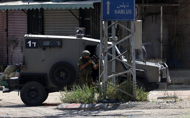 Un soldat israélien se positionnant dans une rue de Tulkarem, en Cisjordanie, le 3 août 2024. (Crédit : Jaafar Ashtiyeh/AFP)