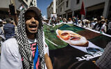 Des manifestants brandissant des pancartes et des drapeaux de la Palestine lors d'un rassemblement contre l'assassinat du chef politique du groupe terroriste palestinien du Hamas, Ismaïl Haniyeh, à Rabat, le 3 août 2024. (Crédit : Fadel Senna/AFP)