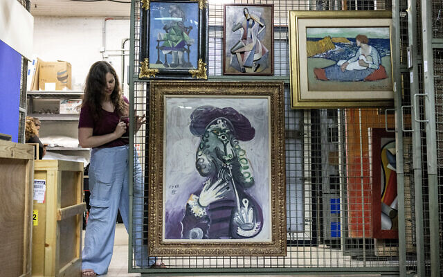 Nathalie Andrijasevic, conservatrice adjointe au Musée d'art de Tel Aviv, manipulant des tableaux qui ont été transférés dans une salle sécurisée souterraine du Musée d'art de Tel Aviv, le 13 août 2024. (Crédit : Oren Ziv/AFP) Nathalie Andrijasevic, conservatrice adjointe au Musée d'art de Tel Aviv, manipulant des tableaux qui ont été transférés dans une salle sécurisée souterraine du Musée d'art de Tel Aviv, le 13 août 2024. (Crédit : Oren Ziv/AFP)