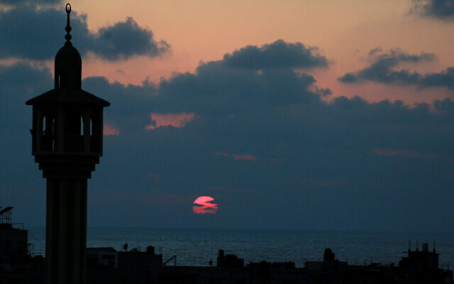 Le minaret d'une mosquée au couché du soleil, à Deir al-Balah, dans le centre de la bande de Gaza, le 16 août 2024. (Crédit : Bashar Taleb/AFP)