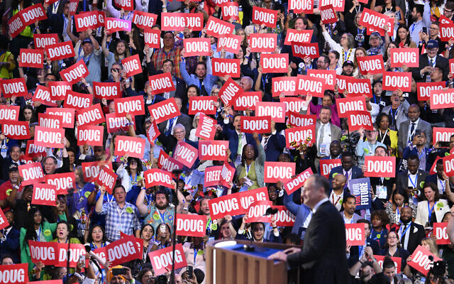 Des délégués brandissant des pancartes alors que Doug Emhoff, deuxième gentilhomme des États-Unis, intervient lors du deuxième jour de la Convention nationale démocrate au United Center, à Chicago, dans l'Illinois, le 20 août 2024. (Crédit : Saul Loeb/AFP)