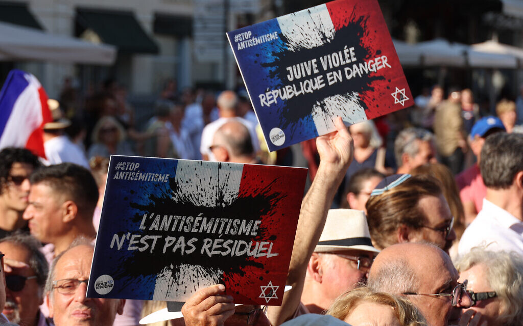 Des personnes portant des pancartes avec le logo du collectif « Nous Vivrons », où l'on peut lire « L'antisémitisme n'est pas résiduel » et « Juive violée, la République est en danger » participent à une manifestation contre l'antisémitisme appelée par le Conseil représentatif des institutions juives de France (Crif) sur la place de la Comédie à Montpellier, le 27 août 2024, suite à l'incendie et à l'explosion de voitures qui ont visé une synagogue de La Grande-Motte, le 24 août 2024. Au moins deux voitures, dont l'une contenait une bouteille de gaz, ont été incendiées le matin du 24 août 2024 devant la synagogue de La Grande-Motte, provoquant une explosion qui a blessé un policier local, ont indiqué la gendarmerie française et le maire de la ville. (Photo Pascal GUYOT / AFP)