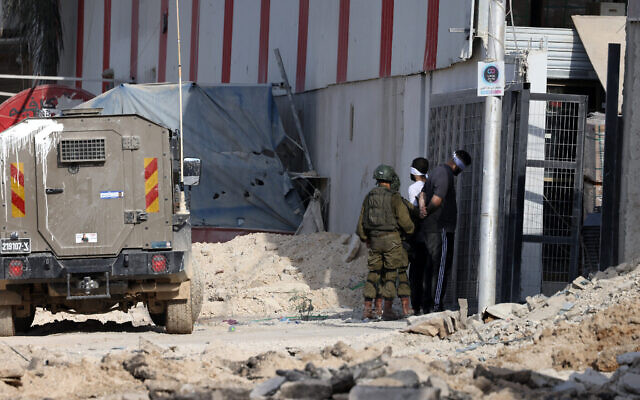 Illustration : Des soldats israéliens arrêtant deux terroristes palestiniens lors d'un raid anti-terroriste, dans le camp de Nur Shams, à proximité de la ville de Tulkarem, en Cisjordanie, le 28 août 2024. (Crédit : Jaafar Ashtiyeh/AFP)