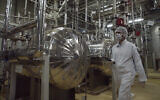 Un agent de sécurité iranien en tenue de protection traversant une partie de l'usine de conversion d'uranium située à l'extérieur de la ville d'Ispahan, en Iran, sur une photo d'archive datant du 30 mars 2005. (Crédit : Vahid Salemi/AP)