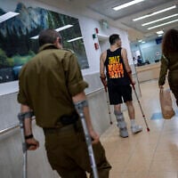Illustration : Des soldats israéliens blessés lors de la guerre contre le Hamas marchant dans l'unité de rééducation de l'hôpital Sheba, à Ramat Gan, le 18 décembre 2023. (Crédit : Oded Balilty/AP)
