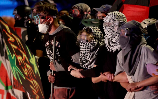 Des manifestants forment une chaine humaine tandis que les forces de l'ordre les font se déplacer le long de Park Avenue, loin du campus de l'Université de l'Arizona, le 10 mai 2024, à Tucson, en Arizona. (Kelly Presnell/Arizona Daily Star via AP)