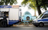Des officiers de police devant le centre islamique de Hambourg et la mosquée Imam Ali lors d'une descente de police, le 24 juillet 2024, à Hambourg, en Allemagne. (Crédit : Daniel Bockwoldt/ dpa via AP)