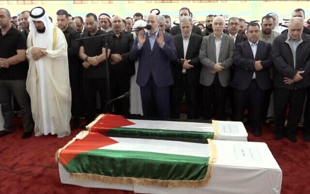 Un haut responsable du Hamas, Khalil al-Hayya (au centre) priant à proximité du cercueil du chef du Hamas, Ismaïl Haniyeh, et de son garde du corps lors des prières funéraires, à Doha, au Qatar, le 2 août 2024. (Crédit : Qatar TV via AP)