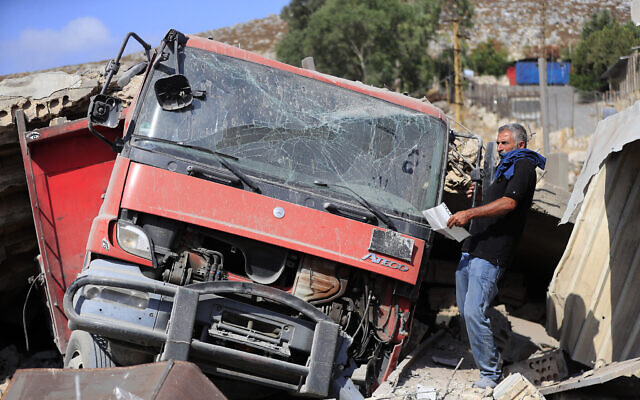 Un homme retirant des documents d'un camion détruit dans une zone industrielle endommagée par une frappe aérienne israélienne, à Wadi al-Kfour, dans la province de Nabatieh, au sud du Liban, le 17 août 2024. (Crédit : Mohammed Zaatari/AP)