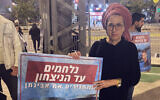 Ditza Or tient une photo de son fils Avinatan, retenu en otage à Gaza, devant le quartier général militaire de la Kirya à Tel Aviv, le 27 décembre 2023. (Mati Wagner / Times of Israel)