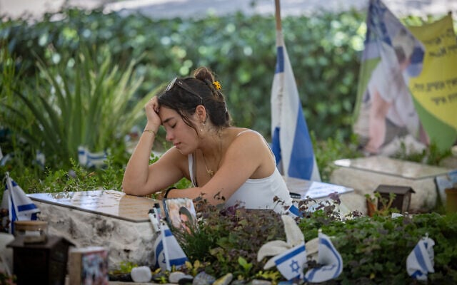 Yuval Tal, la petite amie du sergent Amir Lavi qui a été tué par des terroristes du Hamas dans le sud d'Israël, le 7 octobre, sur sa tombe au cimetière militaire du mont Herzl à Jérusalem, le 18 août 2024. (Crédit : Chaim Goldberg/Flash90) Yuval Tal, la petite amie du sergent Amir Lavi qui a été tué par des terroristes du Hamas dans le sud d'Israël, le 7 octobre, sur sa tombe au cimetière militaire du mont Herzl à Jérusalem, le 18 août 2024. (Crédit : Chaim Goldberg/Flash90)