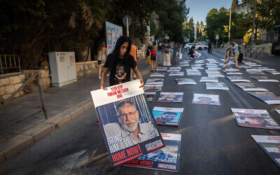 Des membres de la famille et des sympathisants se tenant à côté de photos d'Israéliens retenus en otage dans la bande de Gaza, lors d'une manifestation devant la résidence officielle du Premier ministre, à Jérusalem, le 30 août 2024. (Crédit : Yonatan Sindel/Flash90)