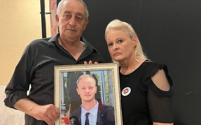 Nasrat et Janka Sammarah avec une photo de leur fils, Mikhael, décédé des suites de ses blessures en raison d'un dysfonctionnement d'un intercepteur du Dôme de fer après un tir de barrage de drones du Hezbollah en date du 9 août 2024. Photo prise le 11 août 2024. (Crédit : Diana Bletter/The Times of Israel)