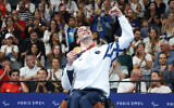 Le nageur paralympique israélien Ami Dadaon brandissant sa médaille d'or, aux Jeux paralympiques de Paris, le 30 août 2024. (Crédit : Lilach Weiss Rosenberg)