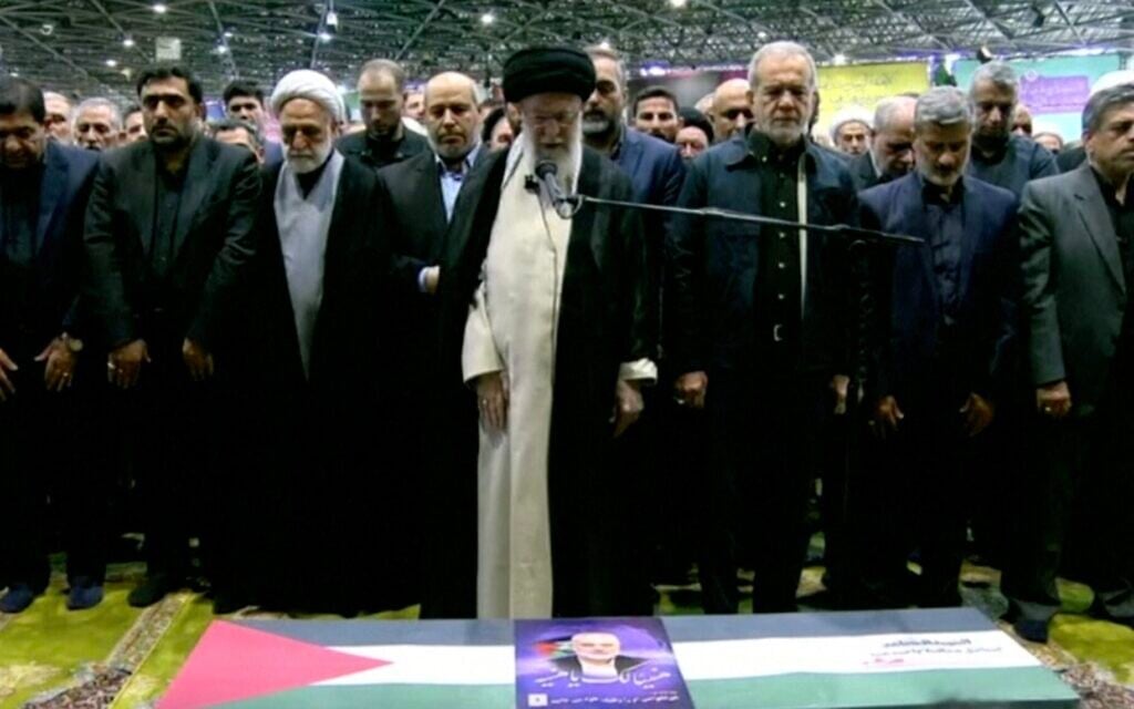 L'ayatollah Ali Khamenei prononçant les prières au-dessus du cercueil du chef du Hamas Ismaïl Haniyeh, le nouveau président iranien Masoud Pezeshkian se tenant à sa droite, à l'Université de Téhéran, le 1er août 2024. (Crédit : Capture d'écran/AFP) L'ayatollah Ali Khamenei prononçant les prières au-dessus du cercueil du chef du Hamas Ismaïl Haniyeh, le nouveau président iranien Masoud Pezeshkian se tenant à sa droite, à l'Université de Téhéran, le 1er août 2024. (Crédit : Capture d'écran/AFP)