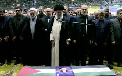 L'ayatollah Ali Khamenei prononçant les prières au-dessus du cercueil du chef du Hamas Ismaïl Haniyeh, le nouveau président iranien Masoud Pezeshkian se tenant à sa droite, à l'Université de Téhéran, le 1er août 2024. (Crédit : Capture d'écran/AFP)