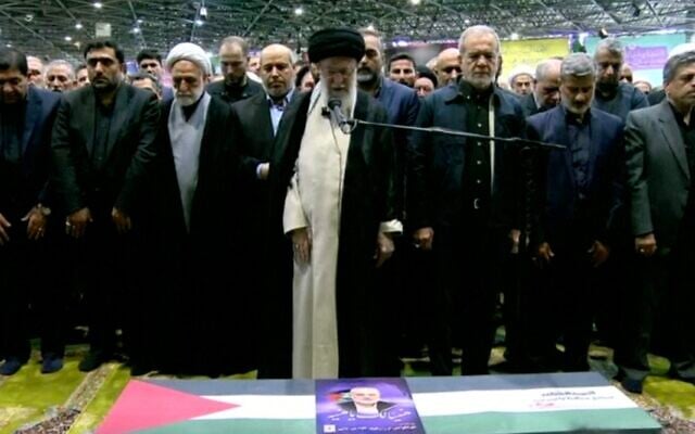 L'ayatollah Ali Khamenei prononçant les prières au-dessus du cercueil du chef du Hamas Ismaïl Haniyeh, le nouveau président iranien Masoud Pezeshkian se tenant à sa droite, à l'Université de Téhéran, le 1er août 2024. (Crédit : Capture d'écran/AFP)