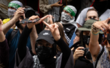 Des manifestants font un triangle inversé avec leurs doigts, symbole du Hamas, au Baruch College, à New York, le 6 juin 2024. (Crédit : Luke Tress)