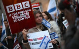 Des manifestants brandissant des pancartes et des drapeaux d'Israël pour demander à la société de qualifier le Hamas de « terroriste », devant le siège de la BBC (British Broadcasting Corporation), à Londres, le 16 octobre 2023. (Crédit : Daniel Leal/AFP)