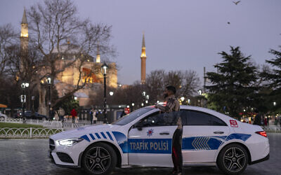 Un homme pose pour une photo à côté d'une Mercedes transformée en véhicule de police, exposée sur la place Sainte-Sophie à Istanbul, le 27 décembre 2023. La police turque dispose désormais d'un parc automobile comprenant des Ferrari, des Bentley et des Mercedes, après avoir saisi des voitures de sport de luxe à des groupes criminels organisés et les avoir transformées en véhicules de la police de la route. (Photo YASIN AKGUL / AFP)