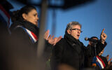 Le fondateur du parti La France Insoumise (LFI) Jean-Luc Melenchon (R) prononce un discours à côté de la députée française LFI Sophia Chikirou lors d'une manifestation pour un cessez-le-feu entre Israël et le Hamas devant les bureaux des Nations Unies à Genève, le 3 février 2024. (Crédit : Fabrice COFFRINI / AFP)