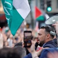Sébastien Delogu, membre du parlement français pour le parti de gauche La France Insoumise (LFI), s'adressant à la foule lors d'un rassemblement sur la place de la République à Paris le 28 mai 2024 pour montrer son soutien aux Palestiniens après que l'agence de défense civile de Gaza a déclaré qu'une frappe israélienne sur un camp de déplacés à l'ouest de Rafah a tué 45 personnes aujourd'hui, quelques jours après une frappe similaire qui a suscité l'indignation du monde entier. Le Parlement français a suspendu M. Delogu pour deux semaines après qu'il ait brandi un drapeau palestinien lors d'un débat animé sur la question de savoir si la France devrait reconnaître l'existence d'un État palestinien. (Crédit :  Geoffroy Van der Hasselt/AFP)