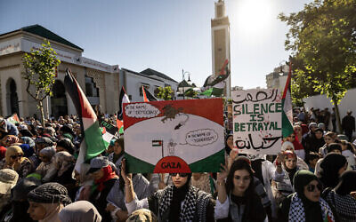 Des personnes brandissant des drapeaux nationaux palestiniens et des pancartes lors d'une marche anti-Israël en solidarité avec la population de Gaza, dans la ville de Tanger, au Maroc, le 7 juillet 2024. (Crédit : Fadel Senna/AFP)