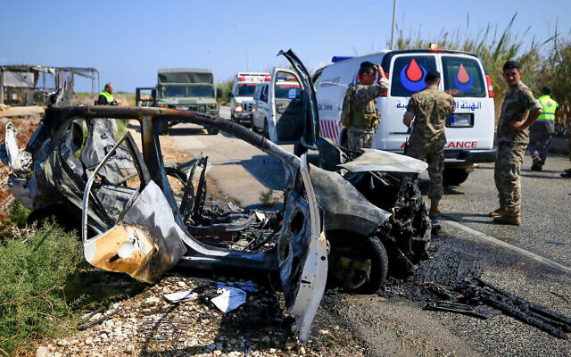 Les forces de sécurité libanaises et les équipes de secours inspectent une voiture calcinée, touchée par une frappe de drone israélien près de Naqoura, à la frontière avec Israël, le 2 septembre 2024. (Crédit : AFP) Les forces de sécurité libanaises et les équipes de secours inspectent une voiture calcinée, touchée par une frappe de drone israélien près de Naqoura, à la frontière avec Israël, le 2 septembre 2024. (Crédit : AFP)