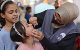 Un médecin palestinien administrant des vaccins contre la polio à des enfants dans le dispensaire du quartier d'al-Daraj, dans la ville de Gaza, le 10 septembre 2024. (Crédit : Omar AL-Qattaa/AFP)