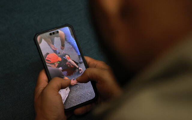 Un homme regardant une vidéo, publiée sur les réseaux sociaux, montrant un homme blessé le 17 septembre 2024, après l'explosion de son bipeur au Liban, une attaque imputée à Israël. (Crédit : Joseph Eid/AFP) Un homme regardant une vidéo, publiée sur les réseaux sociaux, montrant un homme blessé le 17 septembre 2024, après l'explosion de son bipeur au Liban, une attaque imputée à Israël. (Crédit : Joseph Eid/AFP)