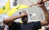 Un homme réagit en tenant un drapeau du Hezbollah lors des funérailles des personnes tuées après l'explosion de centaines d'appareils de radiomessagerie dans une vague meurtrière à travers le Liban la veille, dans un quartier du sud de Beyrouth, le 18 septembre 2024. Des centaines de téléavertisseurs utilisés par les membres du Hezbollah ont explosé au Liban le 17 septembre, tuant au moins neuf personnes et en blessant environ 2 800 dans des explosions que le groupe militant soutenu par l'Iran a imputées à Israël. (Photo ANWAR AMRO / AFP)