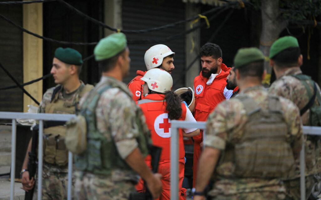 Des soldats de l'armée libanaise et des sauveteurs de la Croix-Rouge se rassemblent sur le site d'une frappe israélienne qui a visé des commandants du Hezbollah dans le sud de Beyrouth, le 21 septembre 2024. (Crédit : AFP)