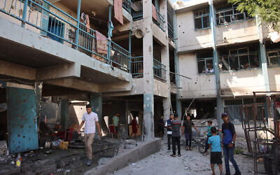 Des Palestiniens inspectant les dégâts sur le site d'une frappe israélienne sur une école abritant des Palestiniens déplacés et des terroristes du Hamas, dans le quartier Zeitoun, à Gaza City, le 21 septembre 2024. (Crédit : Omar Al-Qattaa/AFP)