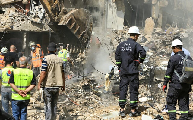 Des sauveteurs fouillant les décombres sur les lieux d'une frappe israélienne qui a visé des commandants du groupe terroriste du Hezbollah réunis dans la banlieue sud de Beyrouth la veille, alors que les opérations de recherche et de sauvetage se poursuivent le 21 septembre 2024. (Crédit : AFP)