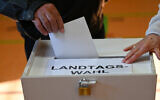 Un électeur déposant son bulletin de vote dans l'urne lors des élections du Land de Brandebourg, à Forst, le 22 septembre 2024. (Crédit : Ralf Hirschberger/AFP)