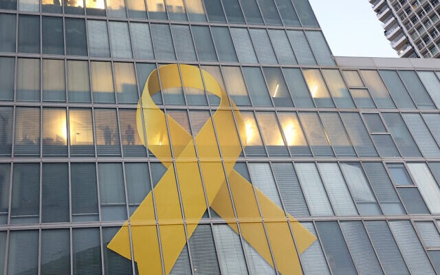 Un ruban jaune en solidarité avec les otages toujours retenus dans la bande de Gaza depuis le pogrom du du 7 octobre 2023 par le Hamas affiché lors d'un rassemblement appelant à leur libération, à Tel Aviv, le 15 août 2024. (Crédit : Gil Cohen-Magen/AFP)