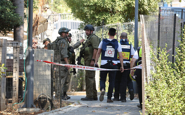 Des secouristes israéliens bouclant le périmètre autour d'une maison touchée par une roquette tirée depuis le Liban, au kibboutz Saar, le 25 septembre 2024. (Crédit : Jack Guez/AFP)