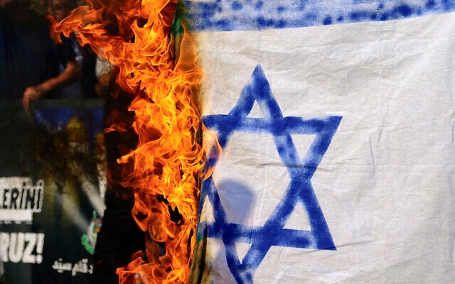 Des manifestants brûlant un drapeau d'Israël improvisé lors d'un rassemblement de protestation contre l’élimination du chef du Hezbollah, Hassan Nasrallah, devant le consulat d'Israël à Istanbul, le 29 septembre 2024. (Crédit : Yasin Akgul/AFP)