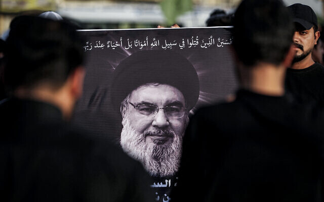 Une photo de Hassan Nasrallah, le chef du groupe chiite libanais Hezbollah qui a été tué dans une frappe aérienne israélienne à Beyrouth quelques jours plus tôt, est affichée lors d'un service commémoratif dans la banlieue est de Bagdad, Sadr City, le 29 septembre 2024, après que l'Irak ait officiellement déclaré un deuil national de trois jours en l'honneur de Nasrallah. (Crédit : AHMAD AL-RUBAYE / AFP)