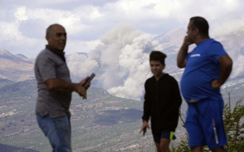 Des Libanais regardent la fumée qui s'élève suite des frappes israéliennes, depuis la ville de Marjayoun, dans le sud du Liban, le 21 septembre 2024. (Crédit : AP Photo/Hussein Malla)